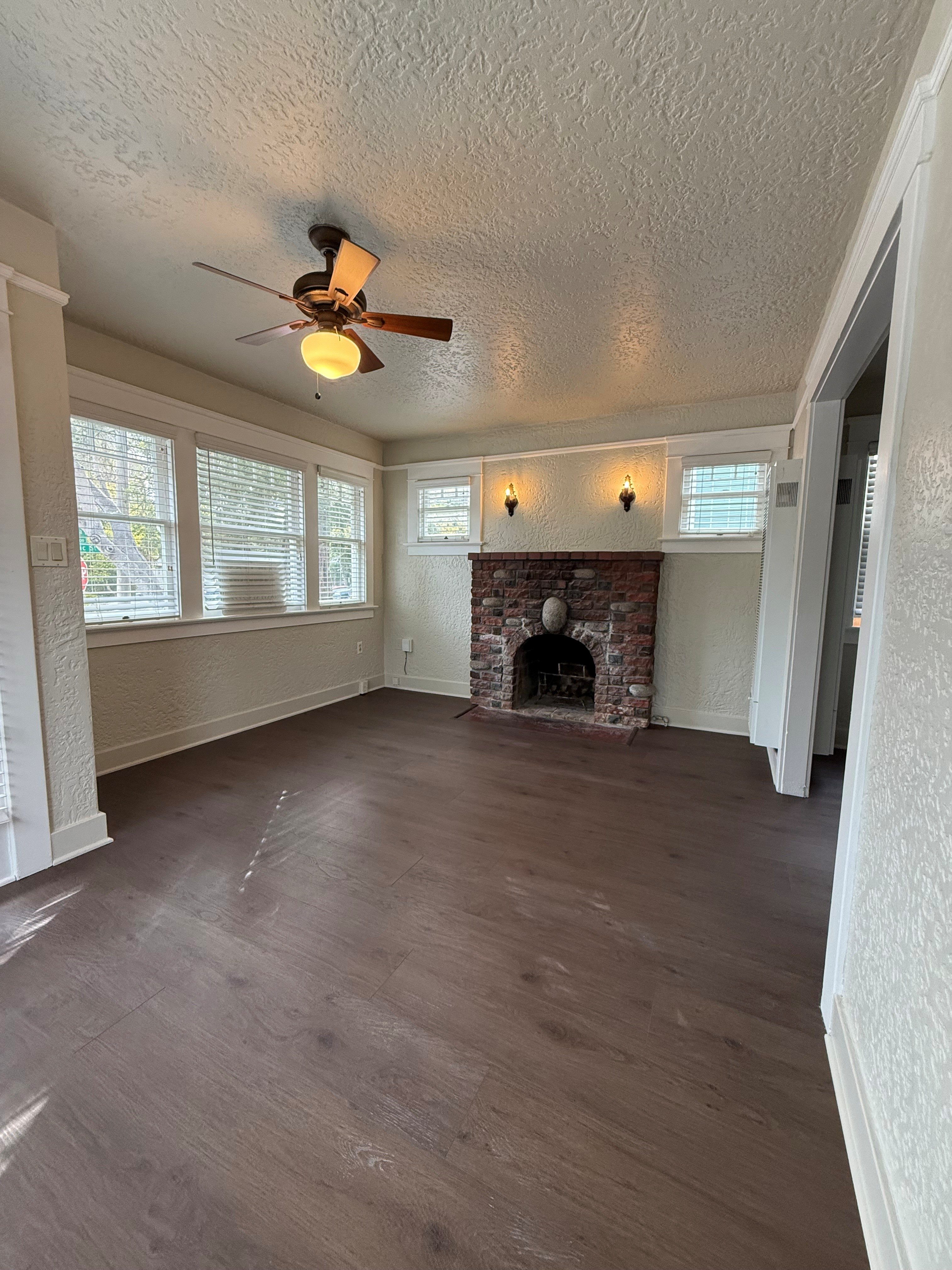A room with a fireplace and a ceiling fan.